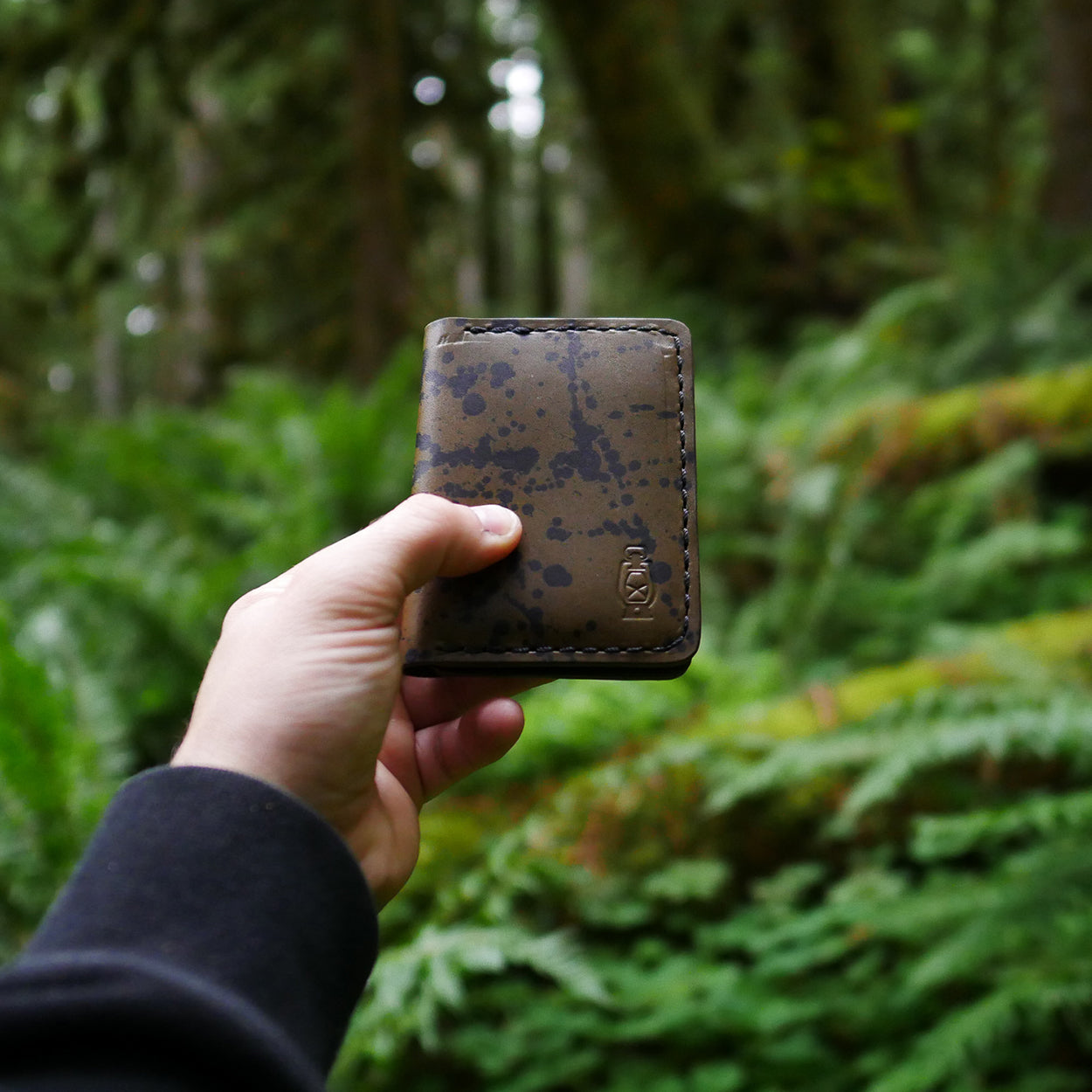 Camouflage in the woods with the Rangeland Splatter Wallet in Olive Splatter by Dark Forest